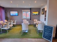 Hotel le Foron في لا روتشيه سر فورون: غرفة طعام مع طاولات وكراسي ولوحة طباشير