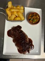 Hotel le Foron في لا روتشيه سر فورون: طبق من اللحم والبطاطا المقلية وعلبة من الصلصة