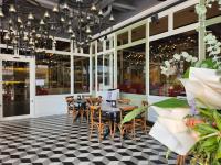 Un restaurante con mesas y sillas sobre un suelo a cuadros. en M Boutique Hotel, en Ipoh