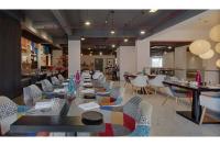 uma sala de jantar com mesas e cadeiras em um restaurante em Inventree Hotel,Bangalore em Bangalore