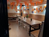 eine Reihe von Tischen in einem Restaurant mit orangefarbenen Fahnen in der Unterkunft Onefam Amstel in Amsterdam