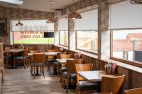 a restaurant with wooden tables and chairs and windows at Livingston Lodge Hotel in Livingston