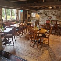Un restaurante con mesas y sillas en una sala. en Coldstreamer Inn, en Penzance