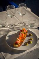 a slice of pizza on a plate on a table with wine glasses at Hotel Le Suquet Cannes in Cannes