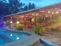 Un patio con piscina y pérgola de madera. en La Luna Beach Resort, en Guiuan