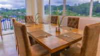 a wooden table in a room with a large window at Salzburg Hotels in Nuwara Eliya