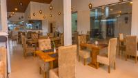 a restaurant with wooden tables and chairs in a room at Salzburg Hotels in Nuwara Eliya