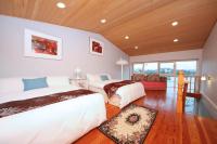 a bedroom with two beds in a room with wooden ceilings at Green Forest Villa in Yilan City