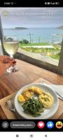a plate of food on a table with a view of the ocean at Poseidon Apartments and Villas by the Sea in Sounio