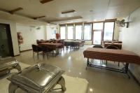 Un comedor con mesas y sillas y ventanas. en Hotel Aagam Executive, en Aurangabad