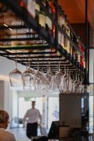 Um monte de copos de vinho pendurados numa prateleira. em LIMNI Boutique Experience Evia em Límni