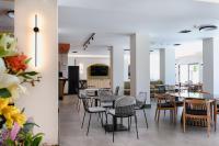 uma sala de jantar com mesas e cadeiras e uma cozinha em LIMNI Boutique Experience Evia em Límni