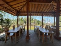 un gruppo di tavoli e sedie in legno sotto un padiglione di Parlezo Cottage Dintor a Ntuar