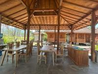 una zona pranzo all'aperto con tavoli e sedie in legno di Parlezo Cottage Dintor a Ntuar