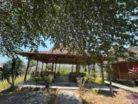 un padiglione con tavolo e sedie in giardino di Parlezo Cottage Dintor a Ntuar