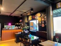 een restaurant met een bar en een tafel en stoelen bij Dark Lights Retreat in Na Jomtien