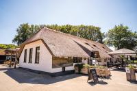 un edificio con tetto di paglia e insegna di fronte di Lodge 'de Haere' a Balkbrug