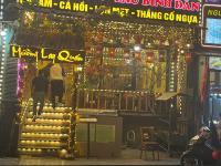 Dos personas subiendo las escaleras de una tienda por la noche. en Quiet Sapa Hotel, en Sa Pa