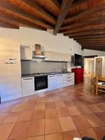 a large kitchen with white cabinets and a stove at Hotel Bersagliere in Laglio