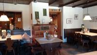 a restaurant with tables and chairs in a room at Schwaigeralm in Kreuth
