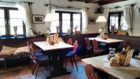 a restaurant with two tables and chairs and windows at Schwaigeralm in Kreuth