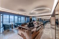 Un restaurante con un bar con sillas y ventanas azules. en Orange Crystal Hotel, Shenzhen Bao'An Joy City, en Shenzhen