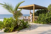 Una mujer parada debajo de un pabellón en la playa. en Sala Beach House, en Ballito