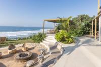 Un patio con fogata junto al mar. en Sala Beach House, en Ballito
