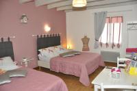 a pink bedroom with two beds and a table at Les rouches in Cormeray