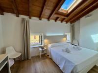 een slaapkamer met een wit bed en een raam bij Corte Impero Hotel & Restaurant in Affi