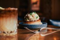 un plato de comida en una mesa con una bebida en The Harpeth Franklin Downtown, Curio Collection by Hilton, en Franklin