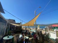 a group of people sitting at tables on a deck at Hostal Casa La Puntilla in Los Molles