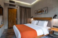 a bedroom with a large white bed with an orange blanket at IOTA Hotel Tbilisi in Tbilisi City
