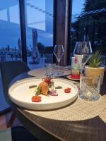 un plato de comida en una mesa con copas de vino en Ariane Hôtel Fos sur Mer, en Fos-sur-Mer