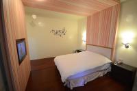 a small room with a bed and a television at Cocos Hot Spring Hotel in Ruisui