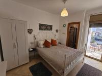 ein Schlafzimmer mit einem weißen Bett und orangefarbenen Kissen in der Unterkunft shohamseaview in Eilat
