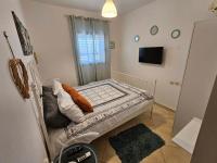 ein kleines Schlafzimmer mit einem Bett und einem Fernseher in der Unterkunft shohamseaview in Eilat