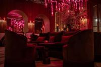 uma sala de estar com um sofá e iluminação vermelha em Hotel SAX Paris, LXR Hotels & Resorts em Paris