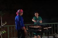een man en een vrouw die eten koken op een grill bij Bamboo Hill Resort in Hữu Lũng
