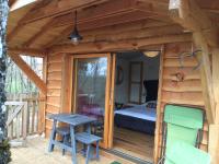 a small wooden cabin with a bed and a table at Cabane Perchée Spa Dordogne La Ferme de Sirguet in Monsac