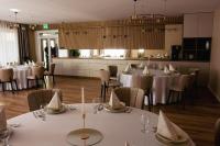 ein Esszimmer mit weißen Tischen und Stühlen in der Unterkunft Palazzo Apartments in Rimavská Sobota