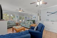ein Wohnzimmer mit blauen Sofas und einem Deckenventilator in der Unterkunft Sweet &#39;N Salty Private Gated Beach Heated Pool in Destin