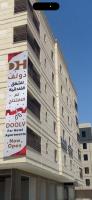 Un edificio con un cartel al costado. en Doolv Serviced Apartments, en Tabuk