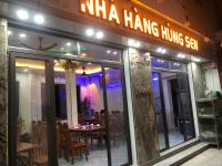 a restaurant with a table and chairs in front of it at Hungsen Homestay & Restaurant Cát Bà in Cat Ba