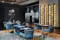 a dining room with tables and chairs and wine racks at Renaissance Zurich Tower Hotel in Zürich