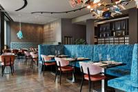 a restaurant with blue velvet booths and tables at Renaissance Zurich Tower Hotel in Zürich