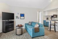 Una sala de estar con un sofá azul y una cocina. en Sonesta ES Suites Chatsworth, en Chatsworth