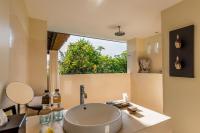 a bathroom with a sink and a large window at Qunci Villas Resort in Senggigi