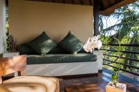 a green couch sitting on a porch with a table at Qunci Villas Resort in Senggigi