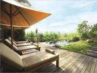 a wooden deck with a couch and an umbrella at Qunci Villas Resort in Senggigi